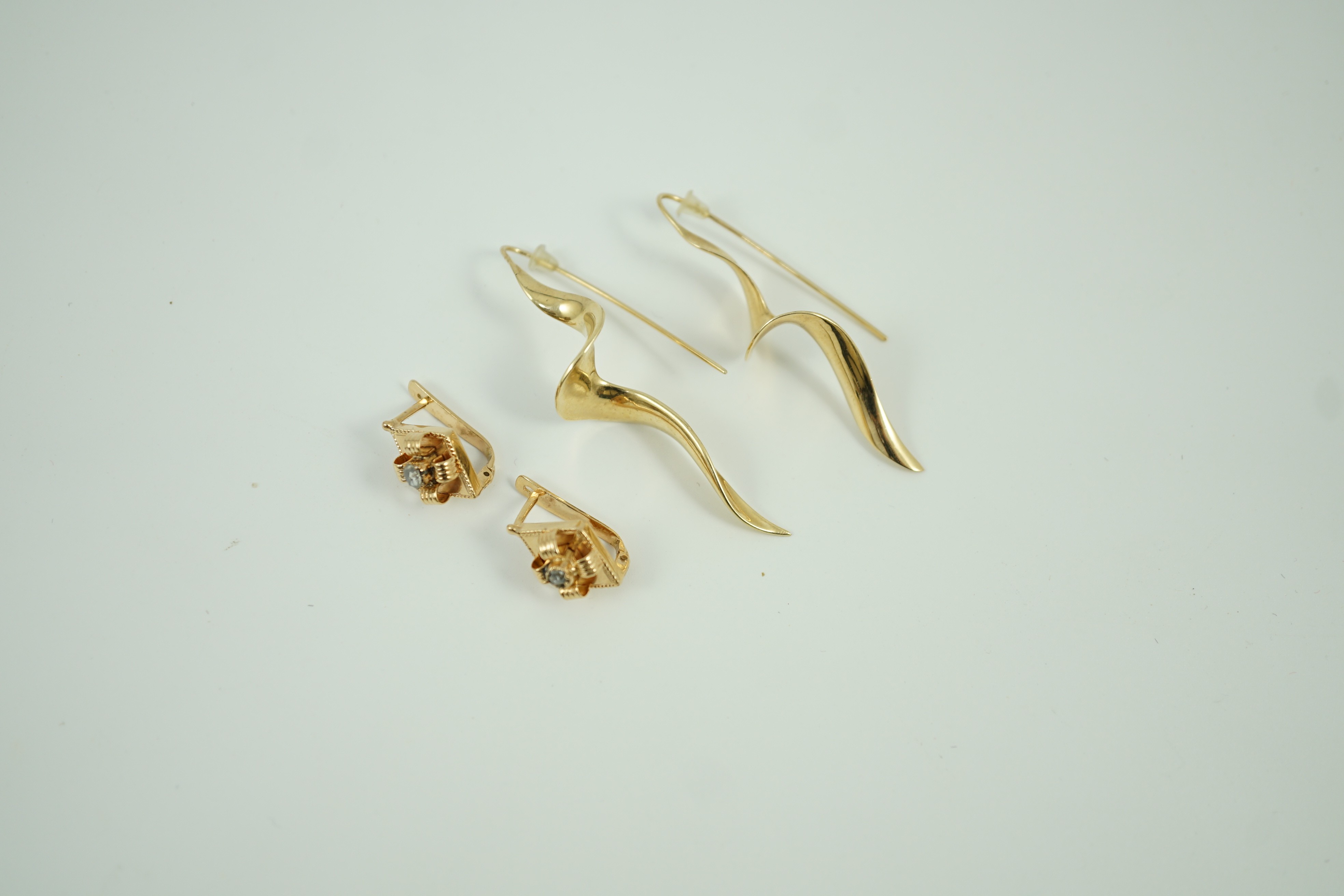 A modern pair of 14k spiral earrings, 50mm, 6.4 grams and a part of yellow metal and solitaire rose cut diamond set earrings, gross 4.2 grams.
